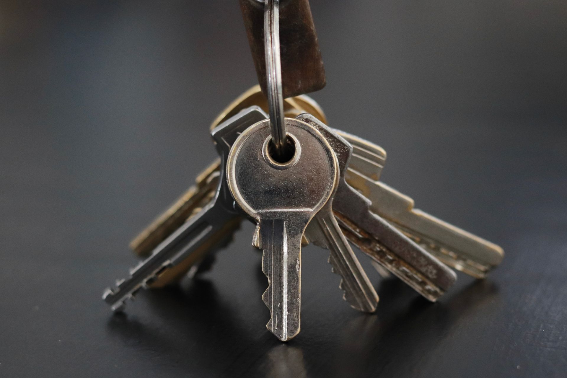 Keys on a key ring, close-up on a dark surface.