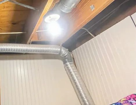 A room with a lot of pipes and a light on the ceiling.
