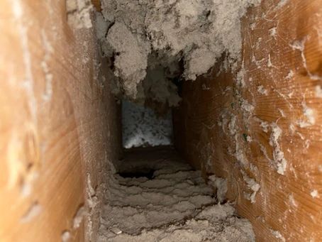 A dirty air vent in a house with a lot of dust coming out of it.