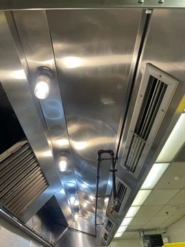 The ceiling of a kitchen with a stainless steel hood and lights.