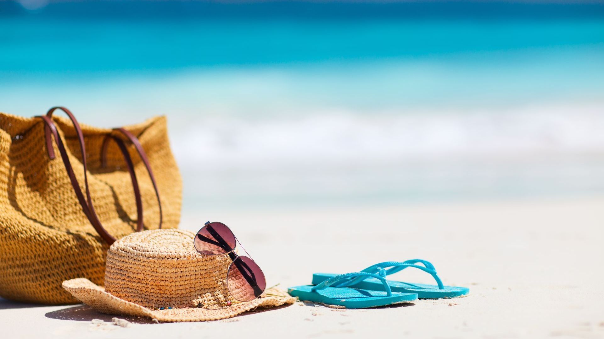 bag, beach hat and slipper on the  beach sand