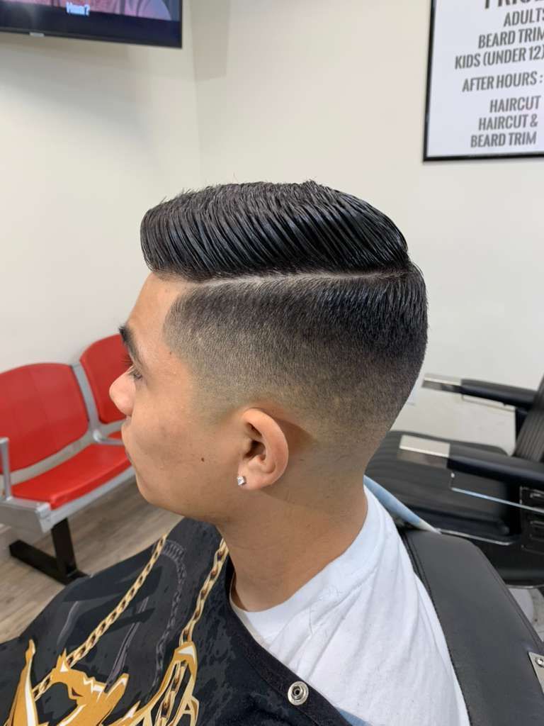 Man with a high fade haircut in a barbershop. Side profile.