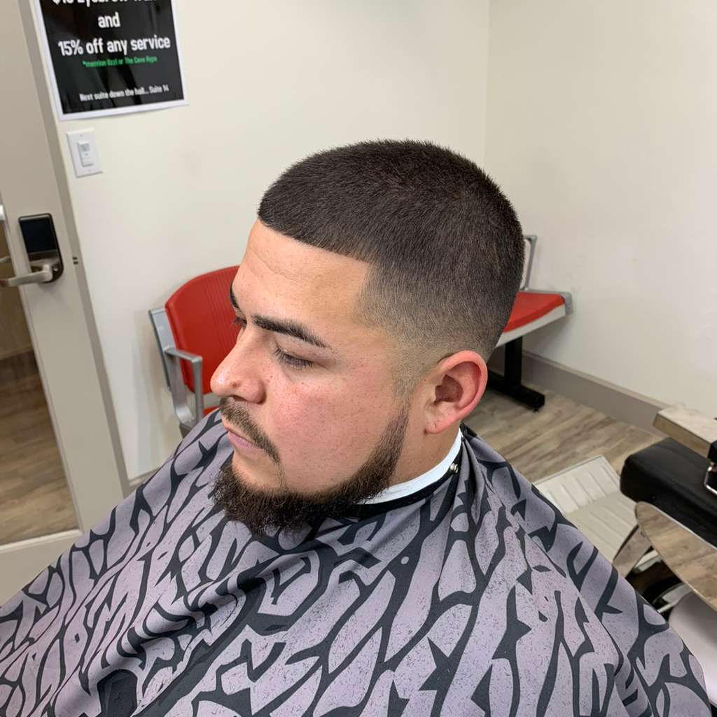 Man with a fresh haircut, fade with beard, in barber chair.