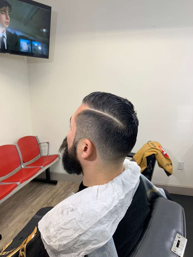 Hairdresser using clippers to trim a client's hair, comb guiding the cut.