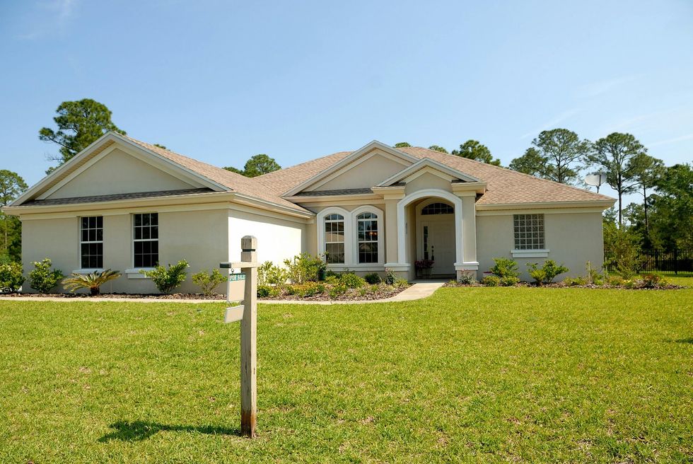 A house with a for sale sign in front of it