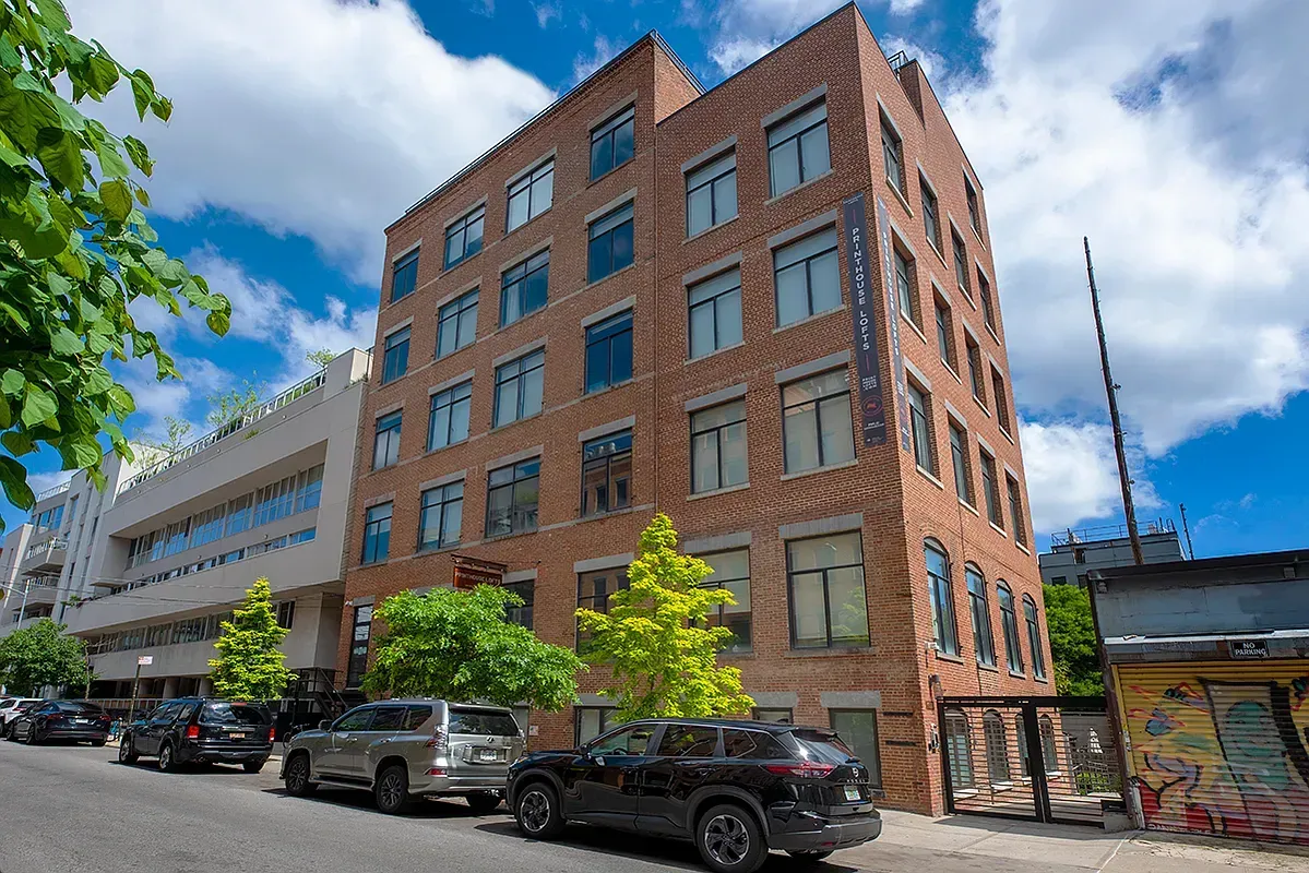 A large brick building with cars parked in front of it.