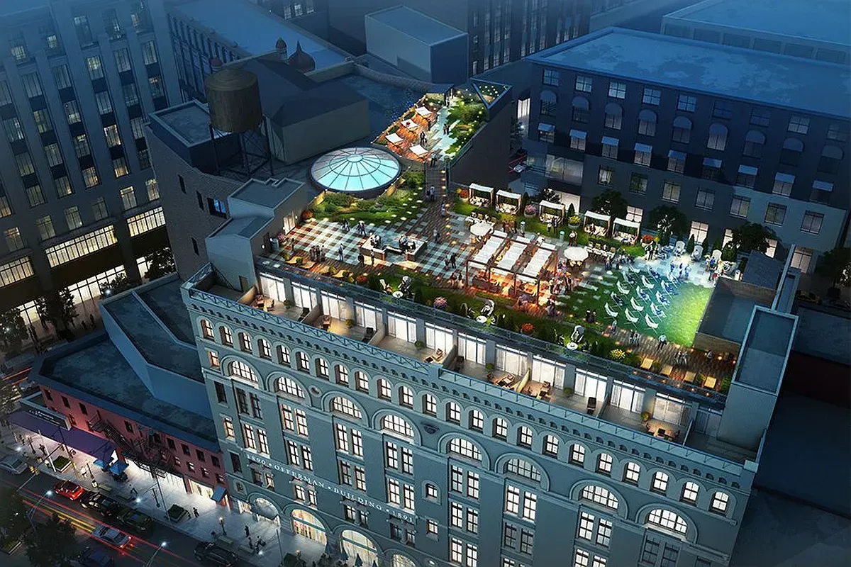 An aerial view of a building with a pool on the roof.