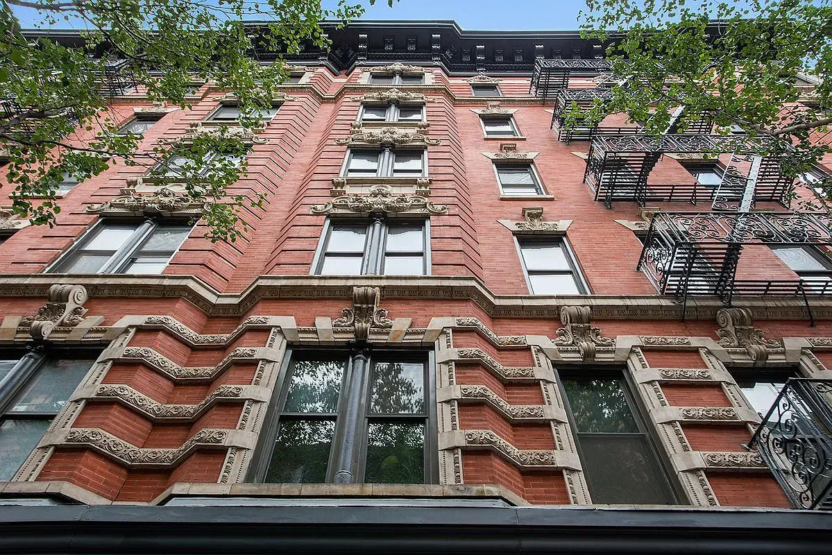 Looking up at a tall brick building with a fire escape