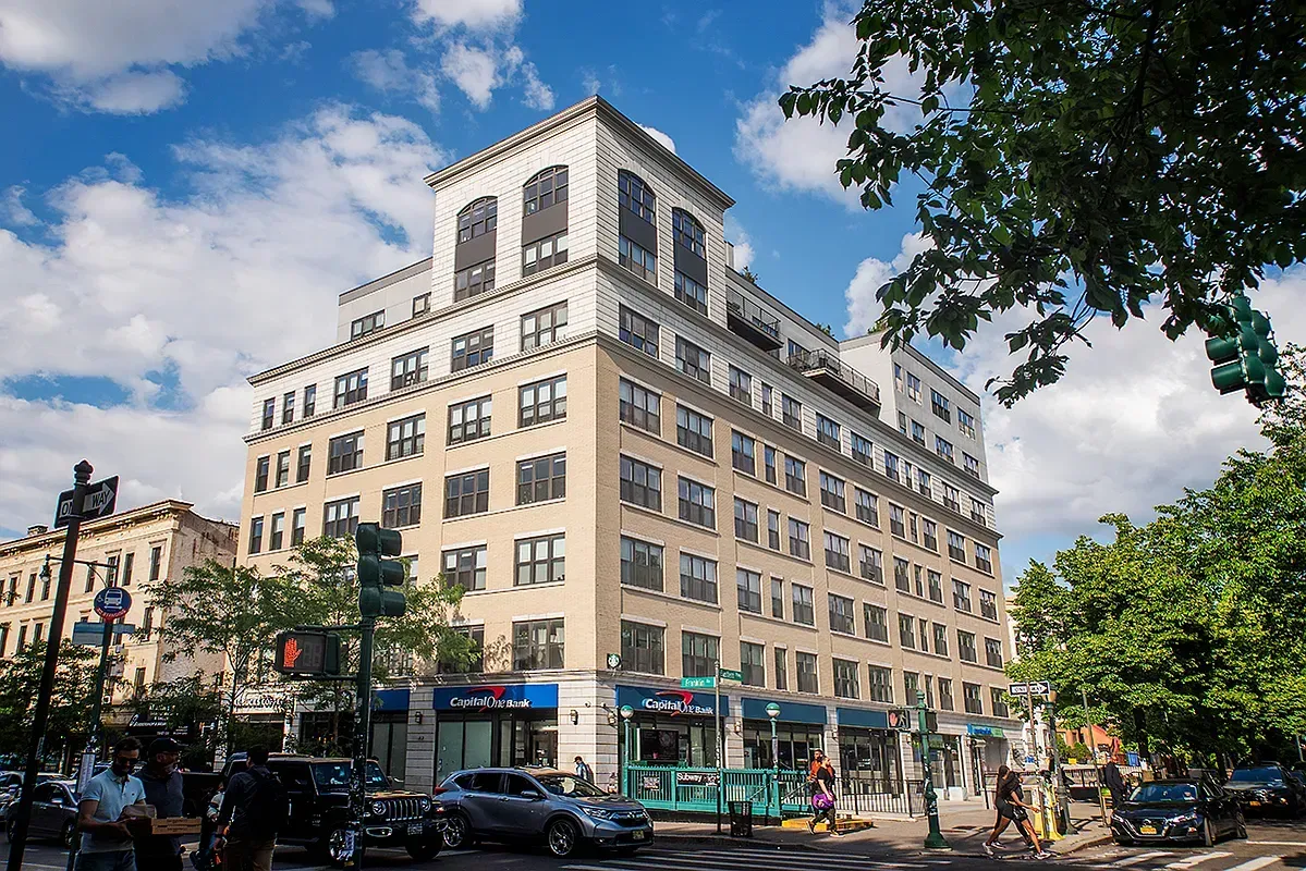 A large building is sitting on the corner of a city street.