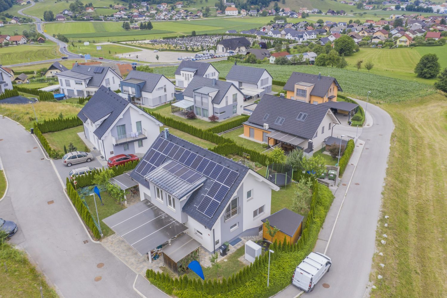 An aerial view of a residential area with houses and solar panels on the roofs.