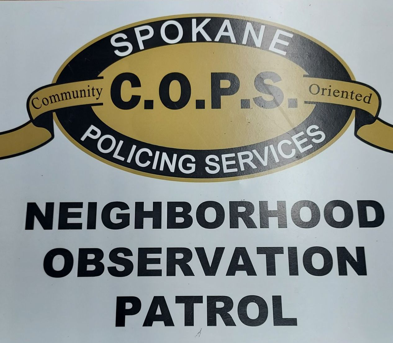 Side door of a white vehicle that has the Spokane C.O.P.S logo on it