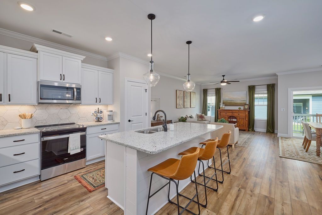 A kitchen with white cabinets and stainless steel appliances