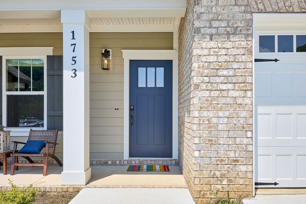 The front of a house with a blue door and a white garage door.