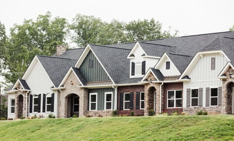 A row of houses are sitting on top of a grassy hill.