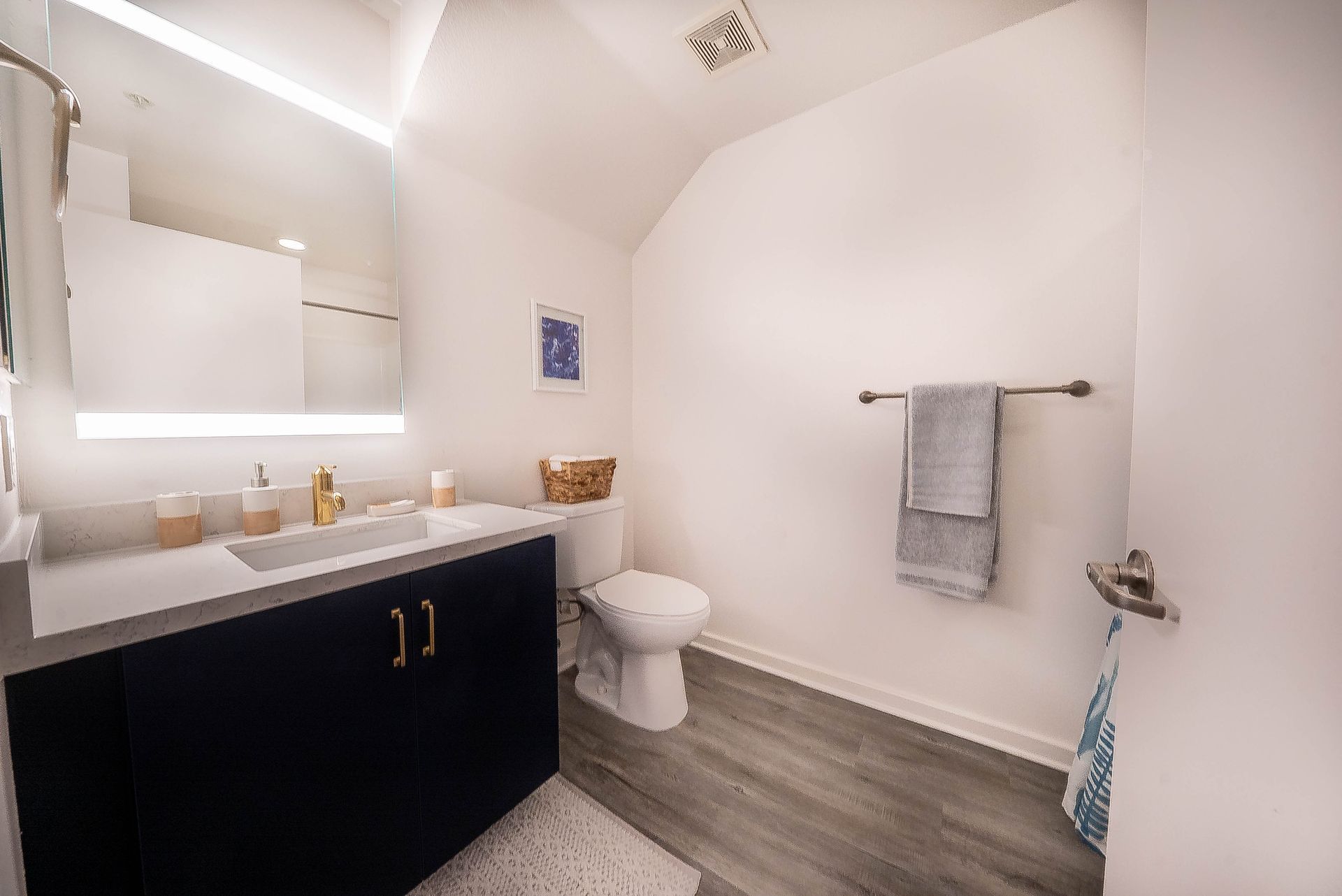 A bathroom with a sink , toilet and mirror.