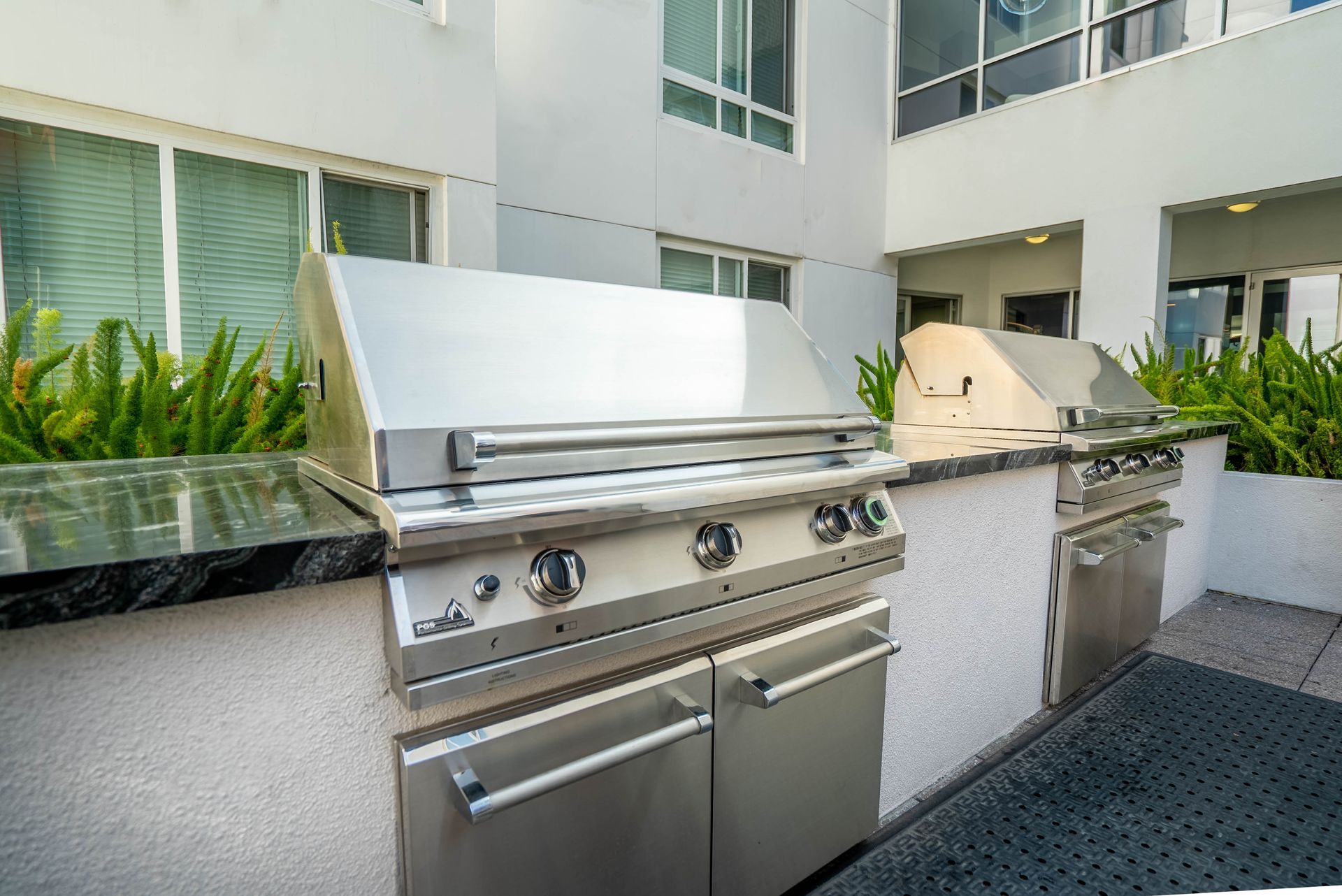 A stainless steel grill is sitting outside of a building