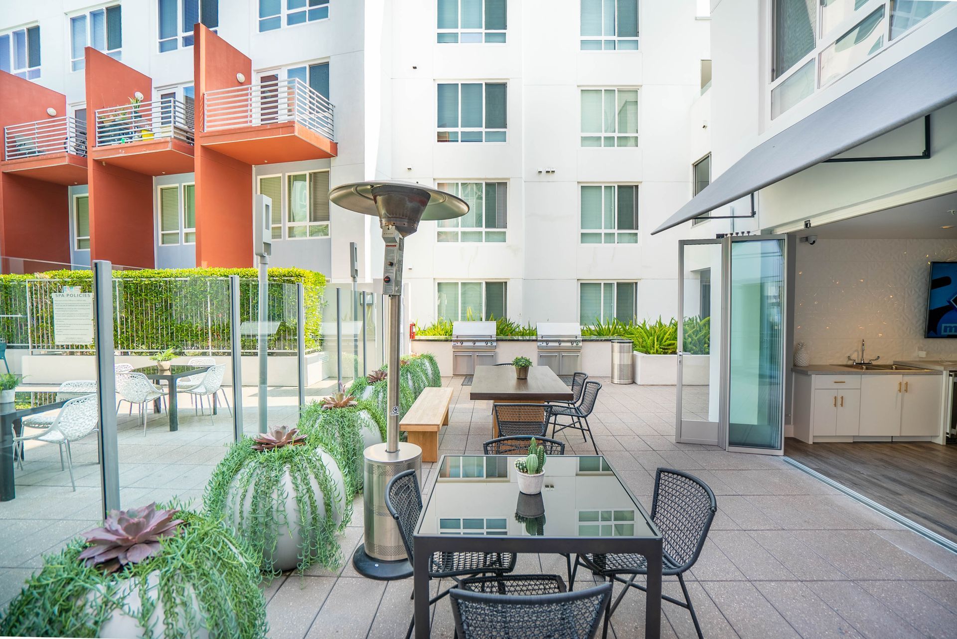 A patio with a table and chairs in front of a building.