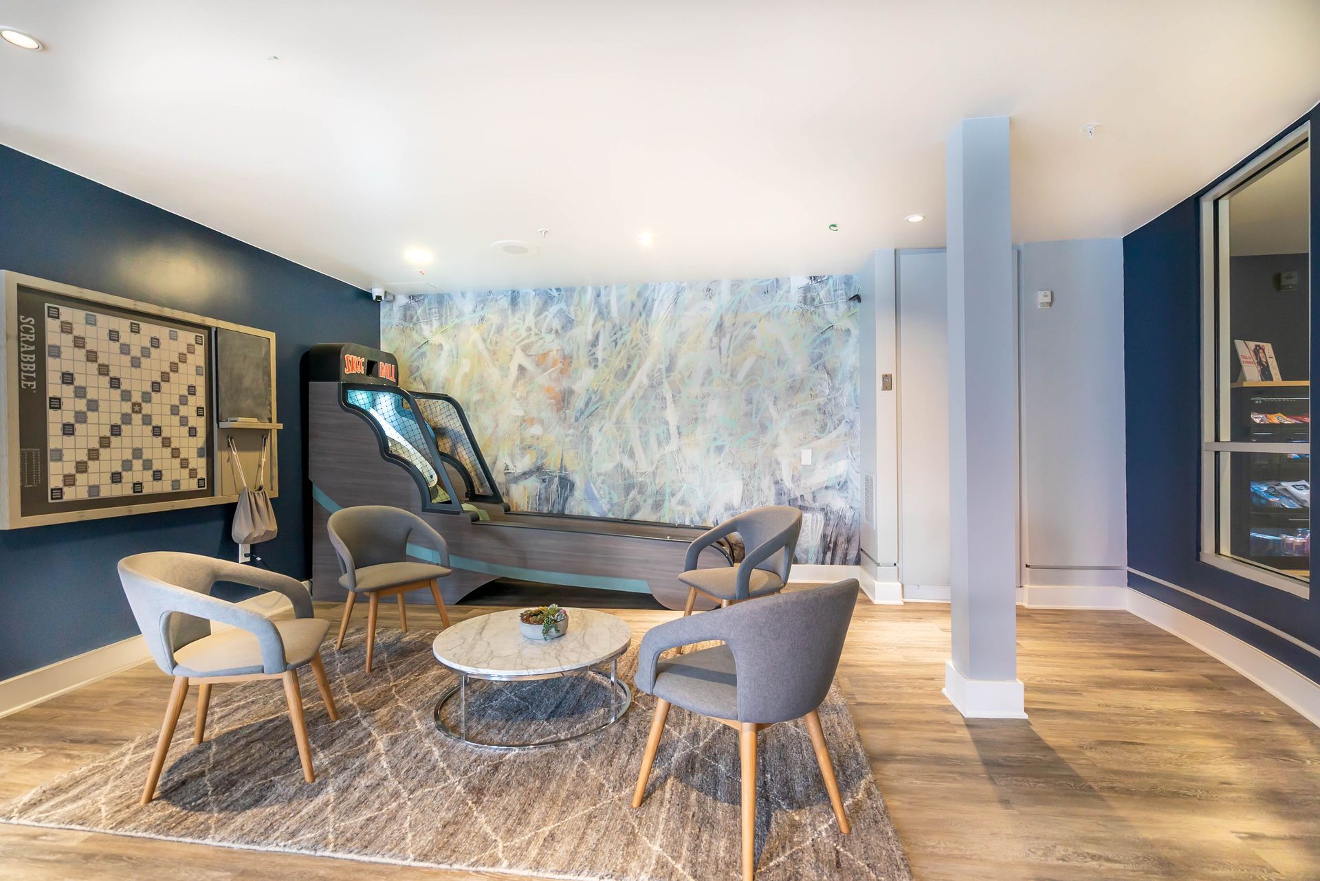 A living room with chairs , a table , and a game machine.