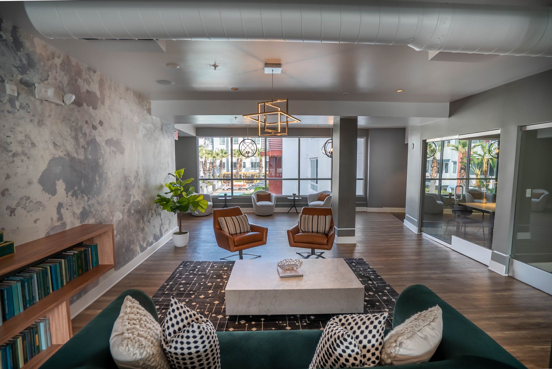 A living room with a green couch , chairs , and a coffee table.