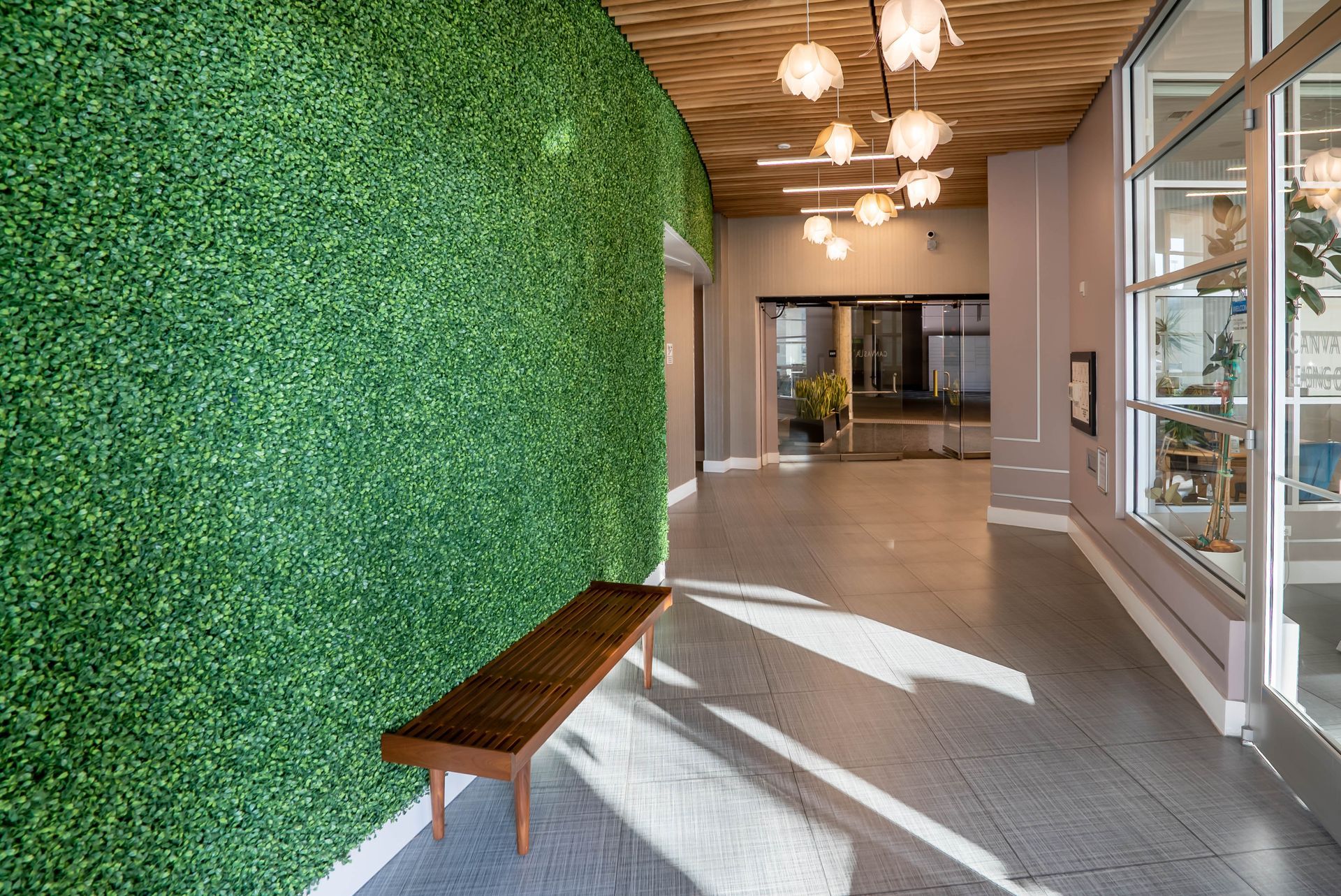 A hallway with a bench and a green wall.