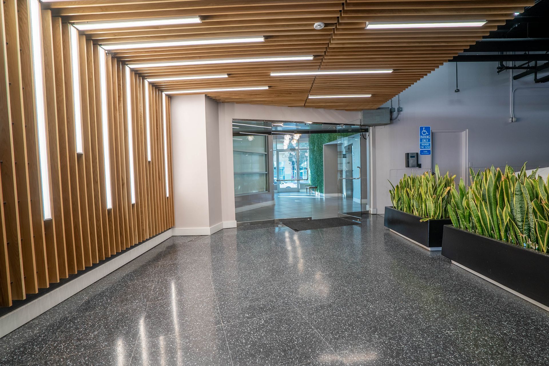 An empty lobby with a wooden wall and a concrete floor.