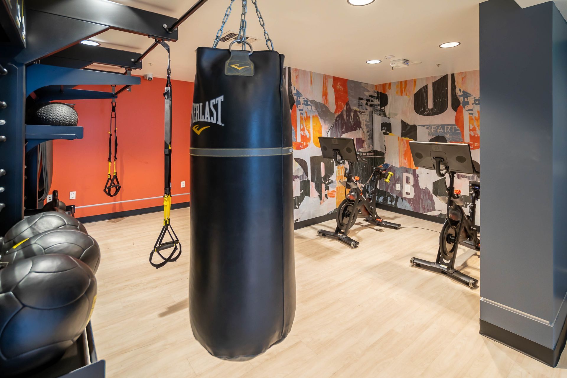 A boxing bag is hanging from the ceiling in a gym.