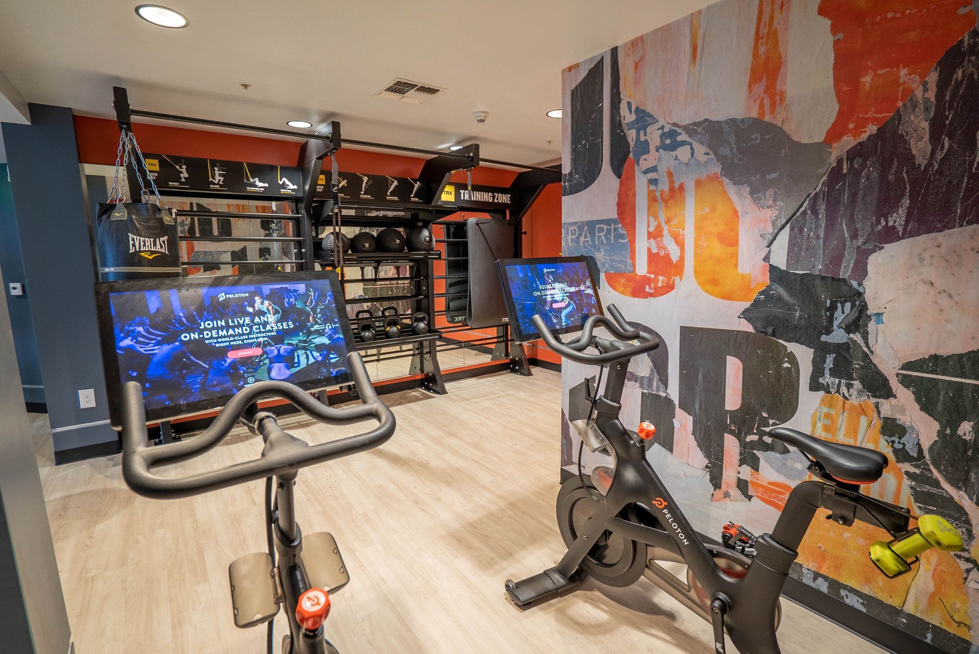 Two exercise bikes are sitting in a gym next to each other.