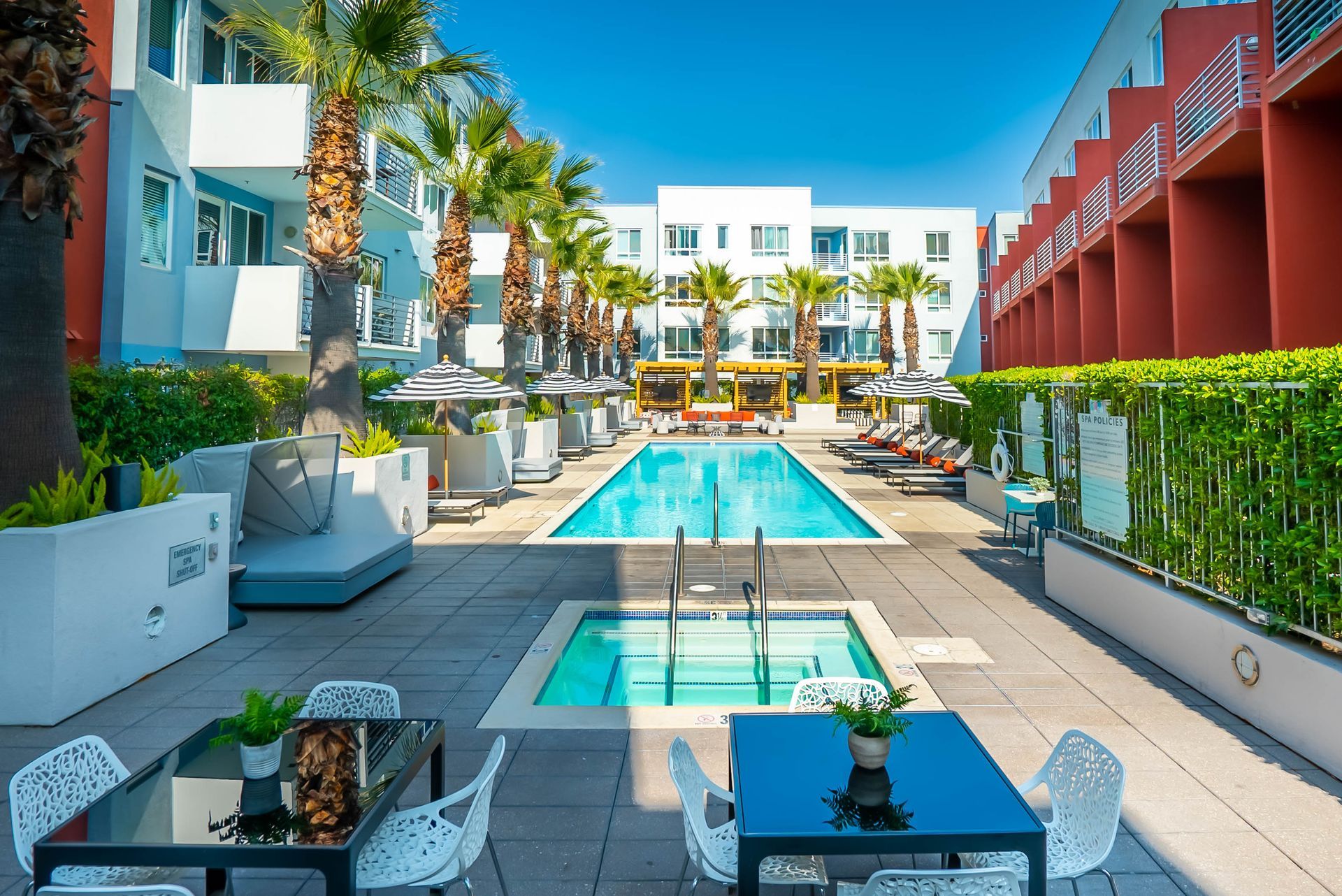 A large swimming pool with a table and chairs in front of a building