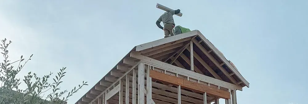 A man is standing on top of a wooden structure.