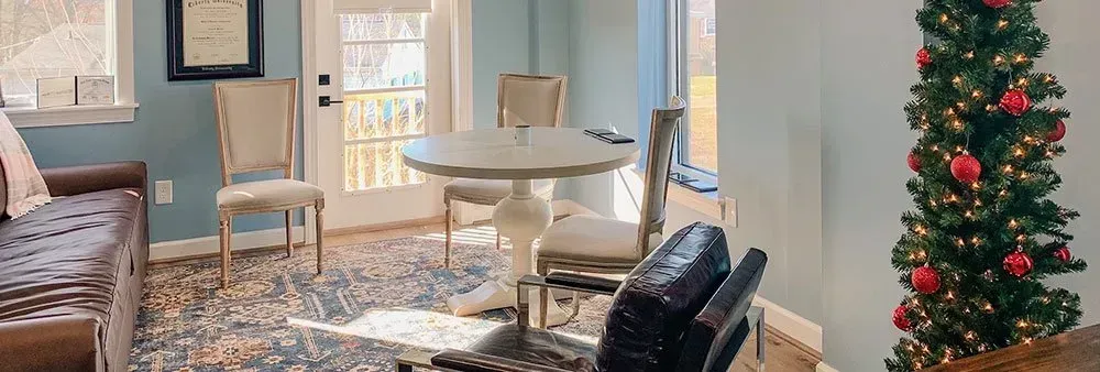 There is a christmas tree in the middle of the living room.