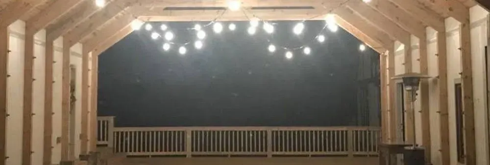 A large room with a balcony and lights hanging from the ceiling.