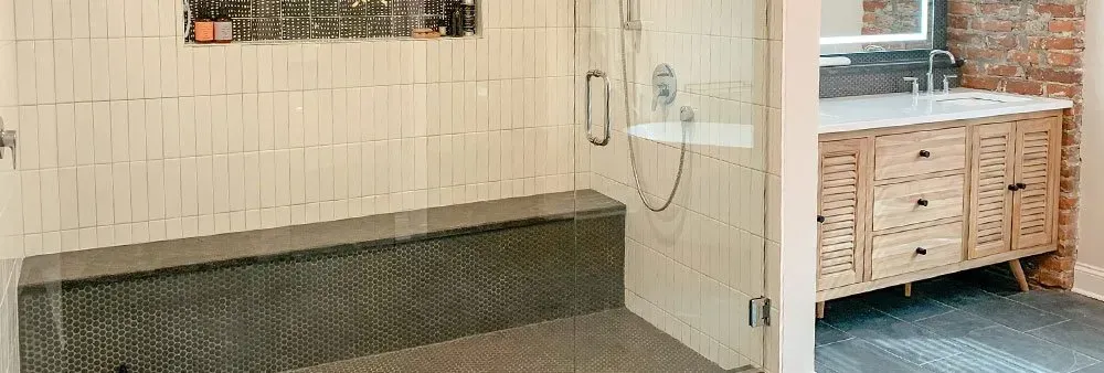 A bathroom with a walk in shower and a sink.