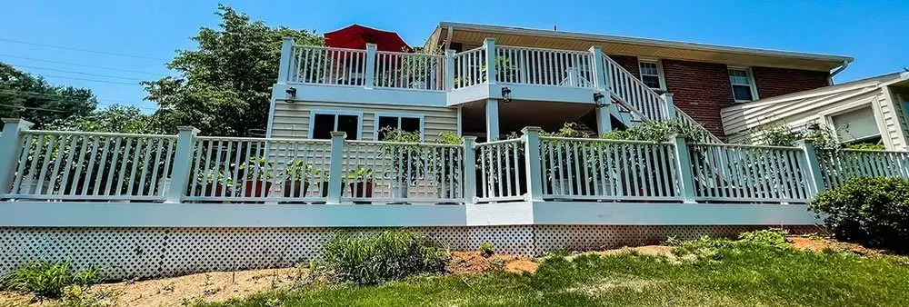 The back of a house with a large deck and stairs.