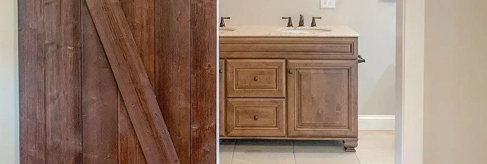 A bathroom with a sliding barn door and a sink.
