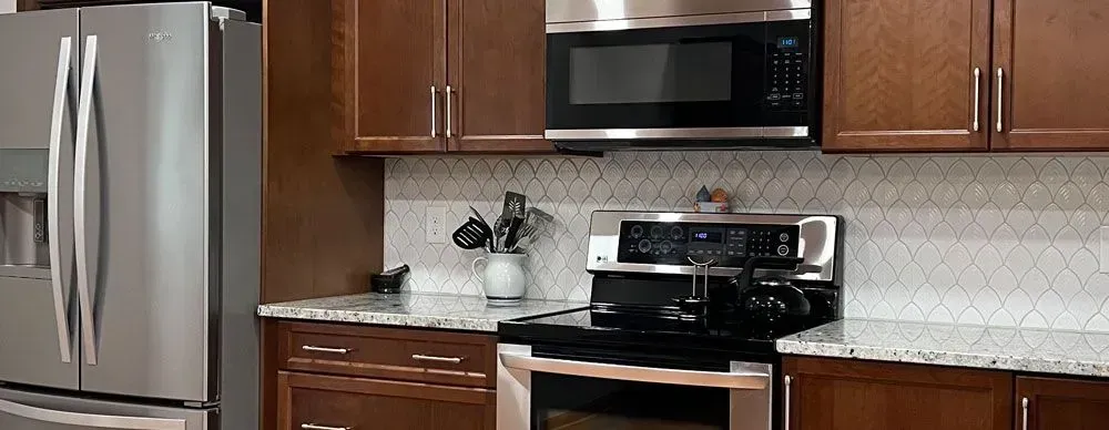 A kitchen with stainless steel appliances and wooden cabinets.