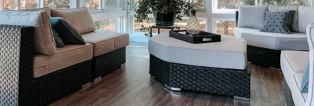 A living room with wicker furniture and a round table.