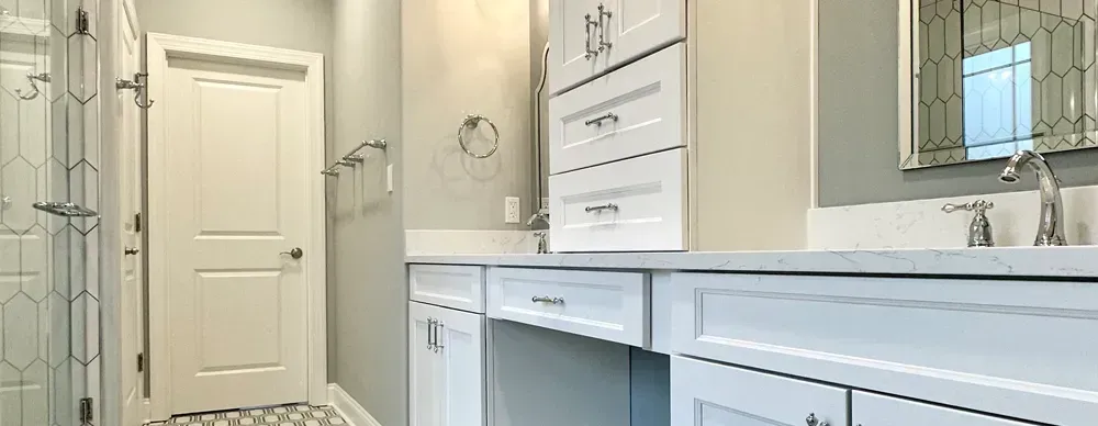 A bathroom with two sinks , a mirror and a walk in shower.