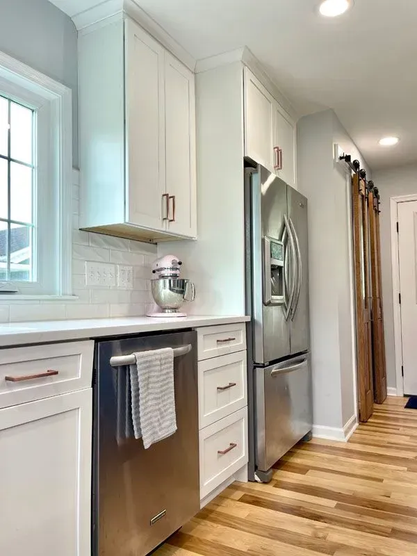 A kitchen with stainless steel appliances and white cabinets
