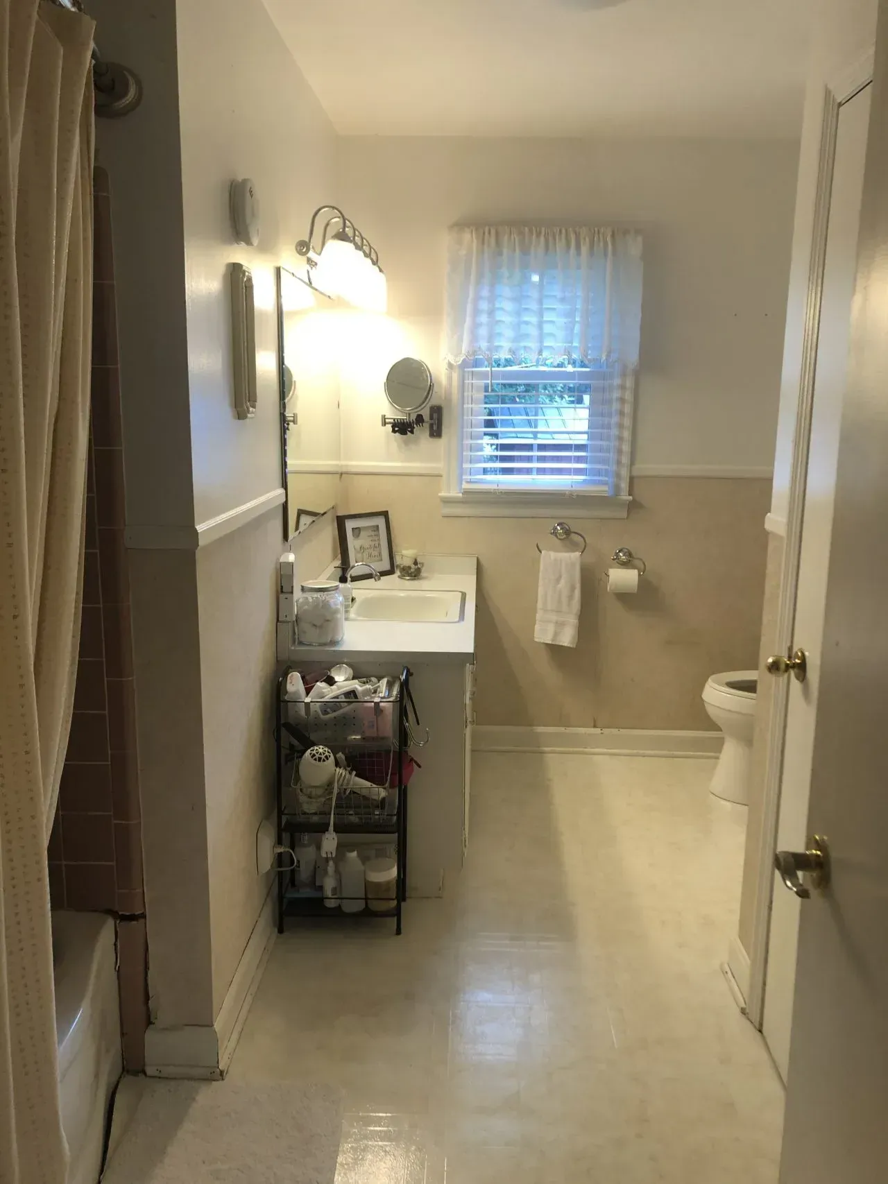 A bathroom with a sink , toilet and window