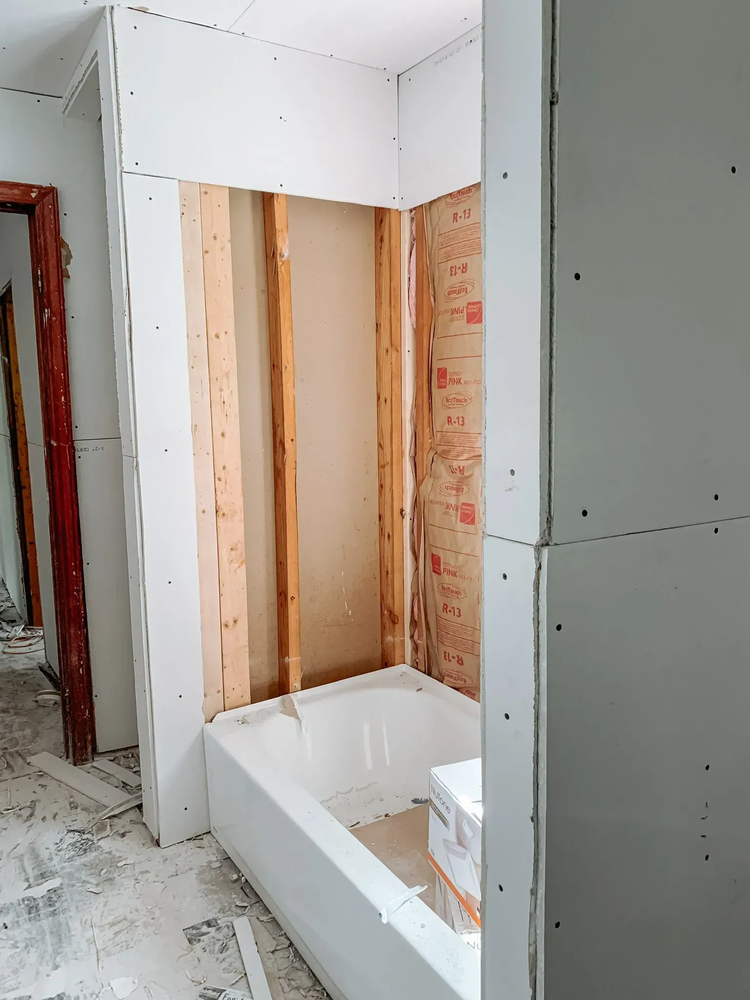 A bathroom under construction with a bathtub in the middle of the room.