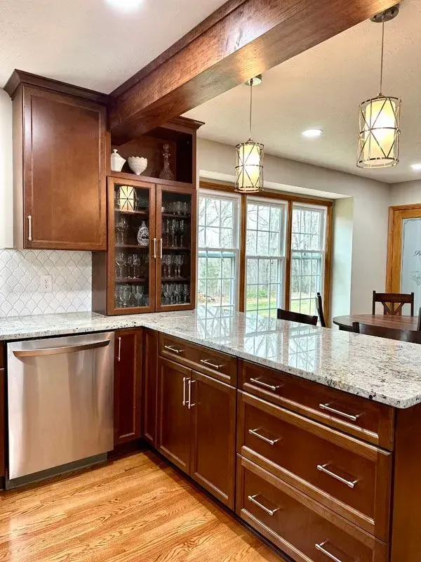A kitchen with wooden cabinets , granite counter tops , stainless steel appliances and a large island.