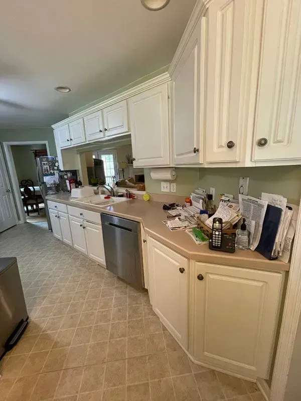 A kitchen with white cabinets and a stainless steel dishwasher.
