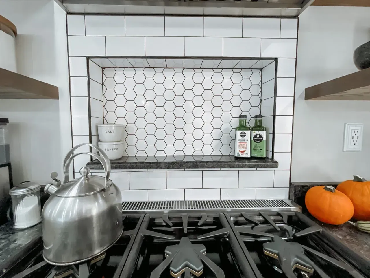 A kitchen with a stove and a kettle on it.