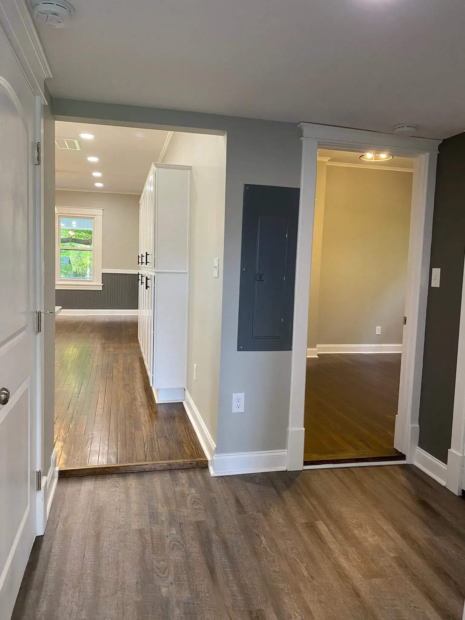 A hallway leading to a living room and a kitchen in a house.