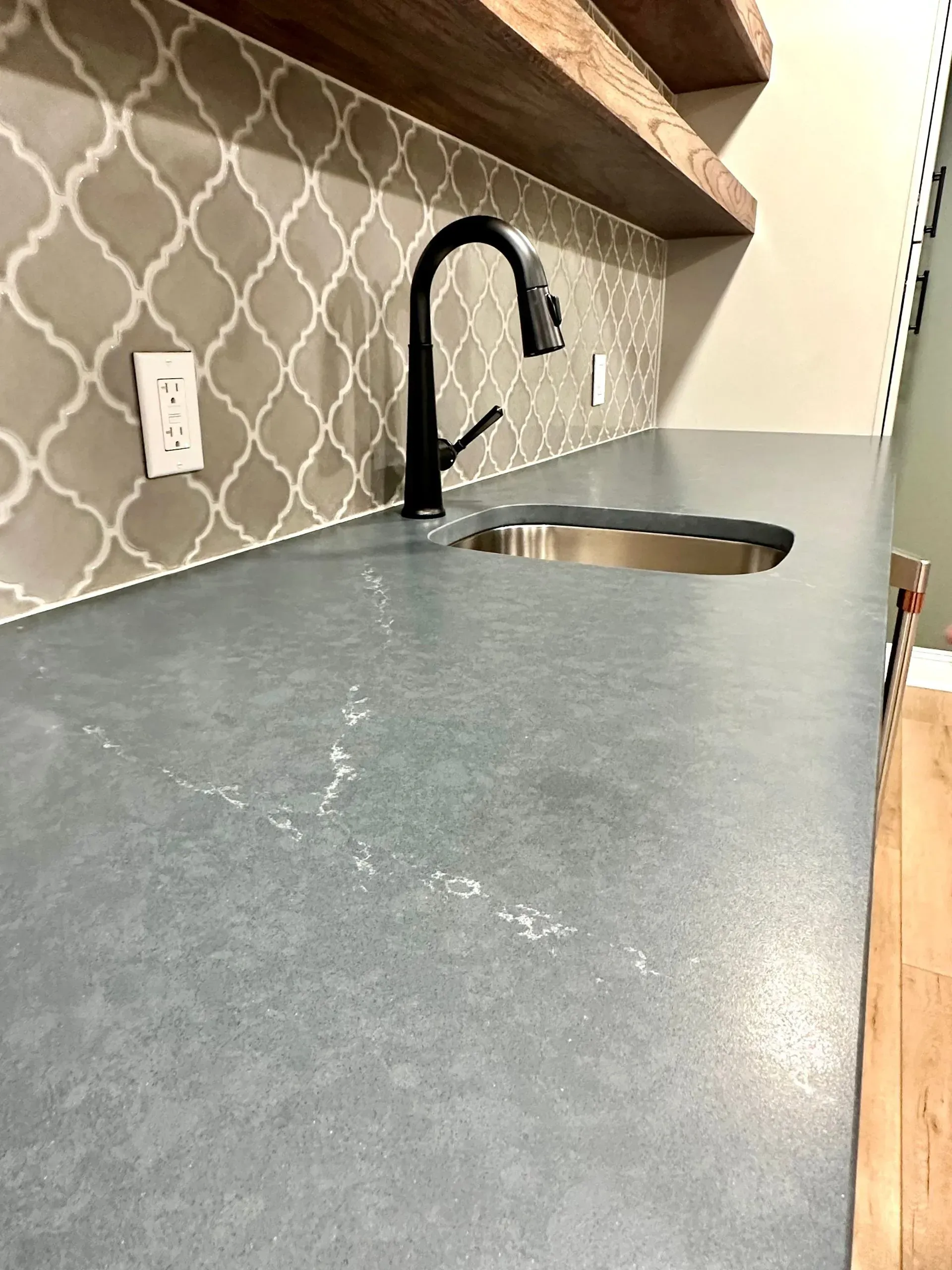 A kitchen counter with a sink and a faucet.