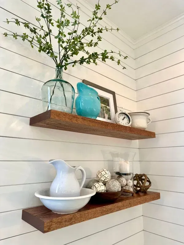 A wooden shelf with a pitcher and a bowl on it