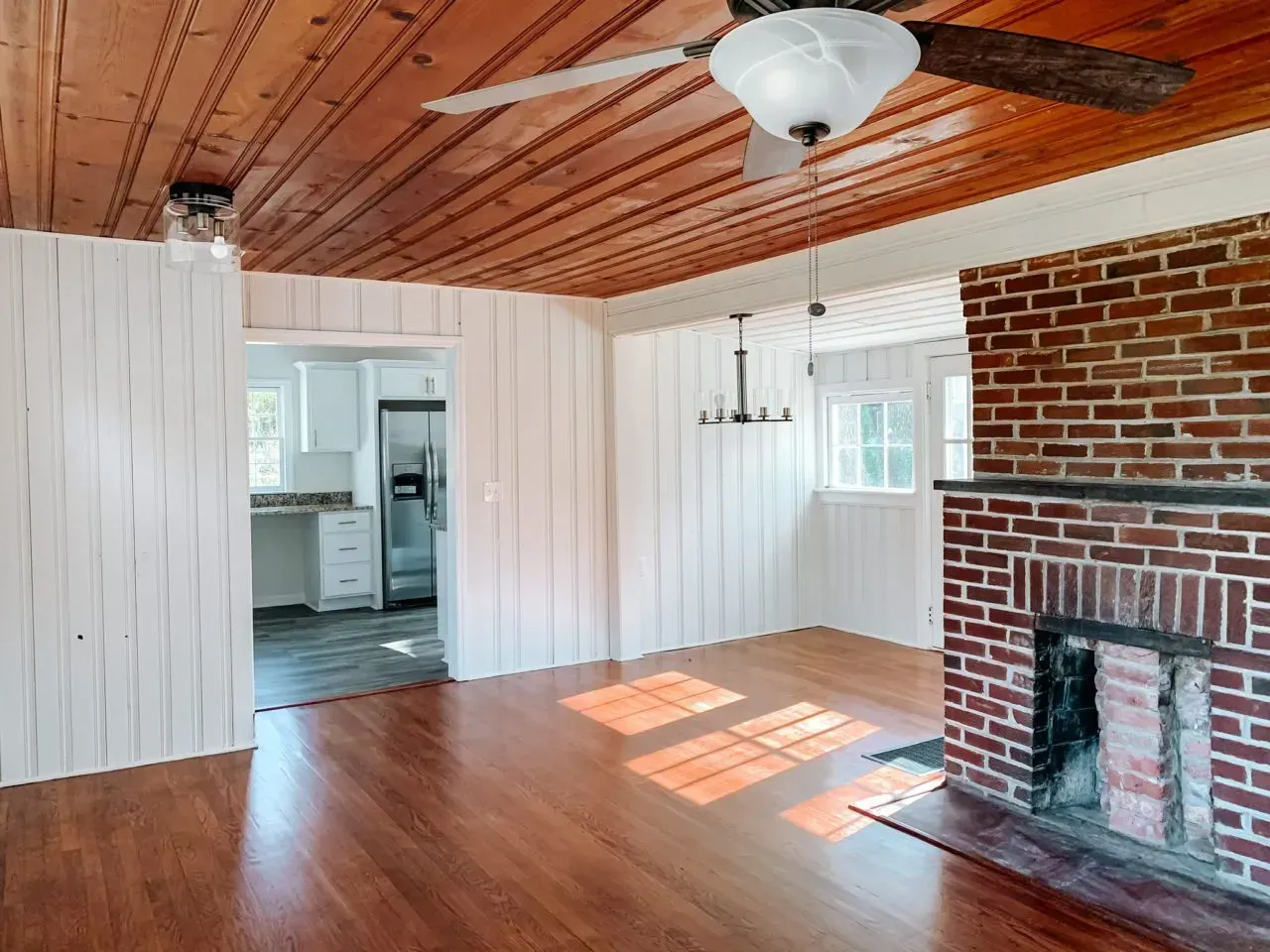 A living room with a fireplace and a ceiling fan