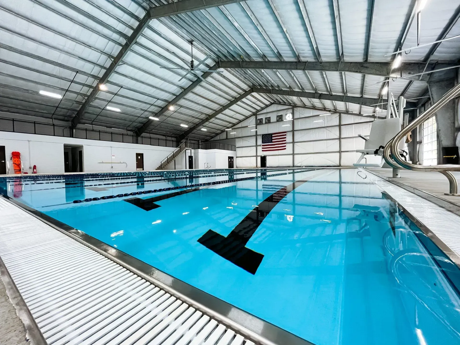 A large indoor swimming pool with a flag on the wall.
