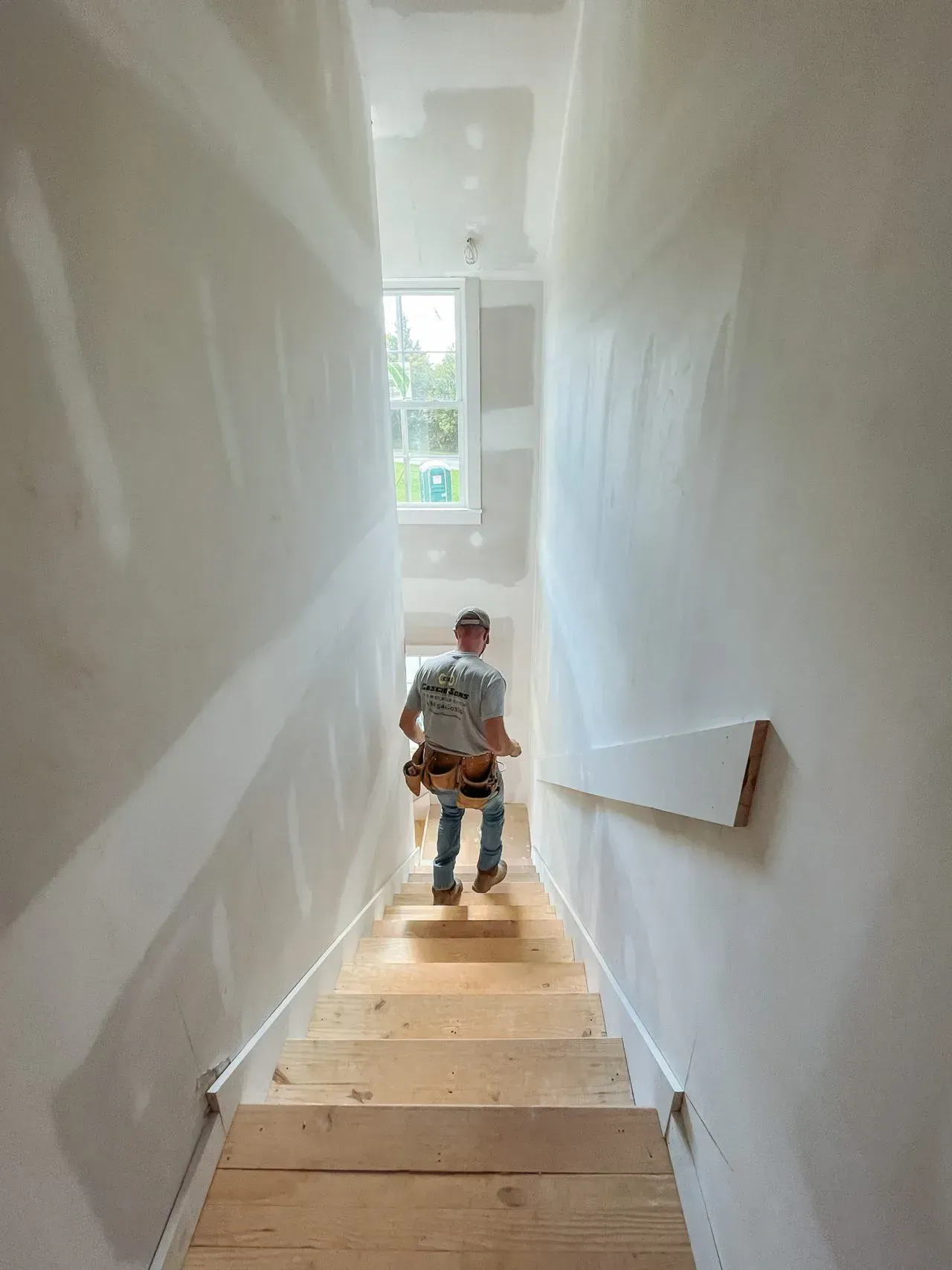 A man is walking down a set of wooden stairs.