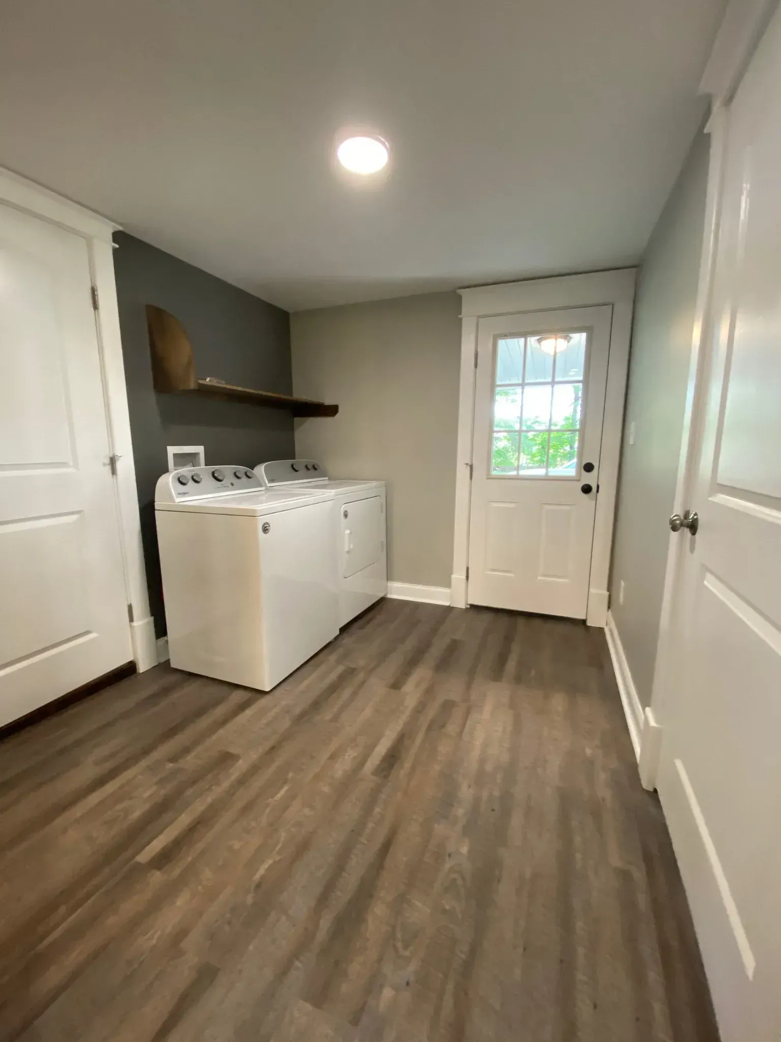 A laundry room with a washer and dryer and a door